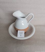 Glazed earthenware pitcher placed inside bowl, showing front view with MaxSold note.