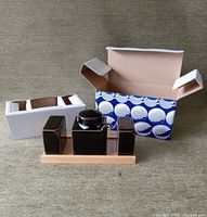 Photo showing the entire set with porcelain shakers and soy sauce pot on wooden tray alongside the decorative blue and white gift box and protective cardboard insert