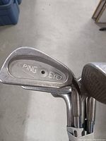 Close-up photo showing the back cavity of a PING Eye2 iron head, highlighting the model engraving and steel shaft joint.