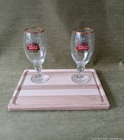 Photo of the wood cutting board with two Stella Artois beer glasses placed on top, showing front logos and details