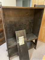 Full view inside the bookcase showing three shelves installed and one shelf removed with hardware packet.