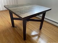 Full view of the antique square table with a dark wood finish, straight legs, and a solid wood top.