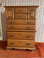 Front view of the vertical wood dresser showing six drawers and two cabinet doors