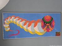 Full view of the large Dragon Kite poster wrapped in shrink wrap, showing the entire kite design in bright colors on a blue background.
