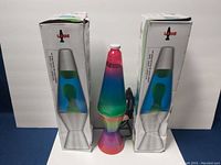Three lava lamps, two in their original boxes and one out, showing size and condition