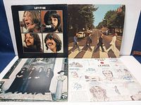 Four Beatles albums with covers shown front and back, including Let It Be, Abbey Road, and two others. Covers have wear and scratches, untested condition noted.