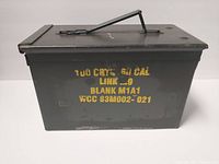 Side view showing yellow stencil text with ammo specifications on the metal box.