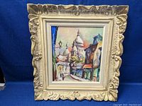 Full view of framed oil painting depicting Sacre Coeur in Paris in ornate white frame
