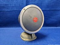 Front angle view of vintage Jensen Speech Master speaker showing metal mesh grill and red emblem.