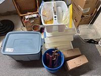 Photo of all storage bins and organizers together, including Rubbermaid Roughneck tub, drawer organizers, blue bucket with tools, and small tan boxes.
