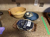 Set of bowls and platters arranged on kitchen counter showing scale and detail