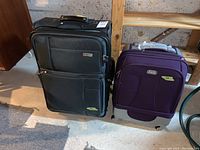 View of two luggage pieces side by side, black Dionite suitcase and purple Ricardo-Elite carry-on