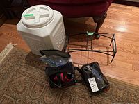 Image showing all items in lot including large plastic pet food container with lid, black metal rack, and several sets of dog boots and pet accessories in plastic bags.