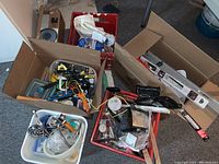 Box with plastic containers filled with various small hand tools, brushes, and hardware items