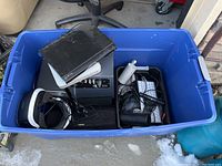Blue plastic storage bin containing all the lot items placed inside, showing the VR headset, DVD player, and audio equipment.