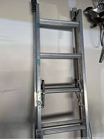 Full view of the Werner aluminum extension ladder with 4 rungs visible, showing overall condition and paint spots.
