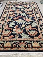 Full view of navy rug laid flat showing entire floral design and border