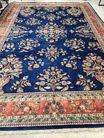 Full view of rug showing blue field and red floral border