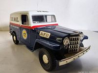 Front three-quarter view of the blue, white, and red mail jeep model with visible chrome grille and bumper, showing U.S. Mail markings.