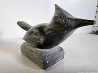 Side and front view of dark soapstone bird carving on rectangular soapstone base.