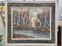 Frontal view of the framed oil painting showing the full wooded landscape with birch trees and water.
