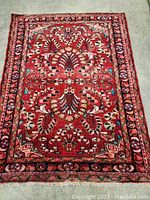 Top-down view of full carpet showing red ground and central floral motif