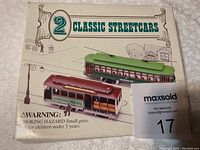 Closed box showing image and title of two classic streetcars, some damage to box visible.