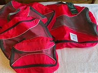 Five red and black G4Free packing bags of varying sizes grouped together on a surface.