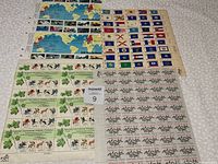 Full view of four different sheets of stamps laid out flat. Includes map-themed, flag-themed, botanical, and dragon emblem designs.