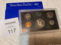 Overview of the 1972 United States Proof Set in plastic case alongside blue folder