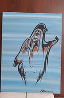 Front view of the acrylic painting showing the indigenous stylized animal figure with blue background and artist signature.