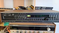 Photo showing vintage Japanese audio receiver with analog tuner, signal strength meter, bass, treble, balance, volume, and input selection controls.