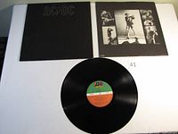 Vinyl record laid out with front album cover and inner printed sleeve showing band live photos.