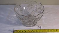 Clear Bohemian crystal bowl shown from front angle, displaying starburst patterns and scalloped rim with measuring tape showing size approximately 8 inches in diameter.