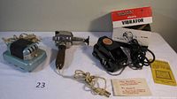 Photo showing three electric massage tools including Wahl Vibrator with original box and manual on white surface