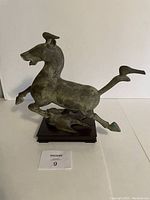 Front angle showing the galloping horse mounted on wood base with visible green patina.
