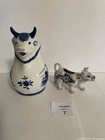Photo showing the Delft Blue handpainted pitcher and smaller cow-shaped creamer side by side on a light background.
