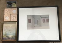 Photo showing the collection including the framed Wasselman painting of a beach scene with grasses, the framed 'Red Shutters' photograph, four seashell coasters in sand tones, and the 2019 Alyssa coastal desktop calendar with easel.