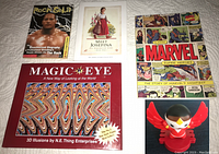 Top view of all five items: four books and one Marvel Falcon figure on a white surface.