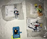 All four figurines in original packaging on white surface.