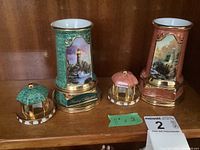 Both ceramic lighthouse figurines with removable tops placed front view showing colors and decoration