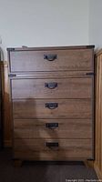 Front view showing five drawers with metal handles, full dresser height and rustic veneer finish.