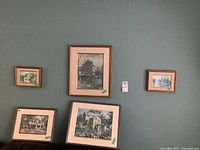 Grouped view of five framed prints depicting mills and buildings from local area in various sizes and frames on flat surface