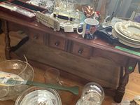 Photo showing solid wood coffee table with multiple small drawers and items on top, part of the Vilas furniture lot.