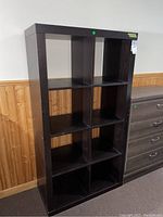 Front view of solid wood cubed shelving unit with 8 open cubed compartments, black/dark brown finish.