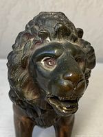 Close-up of the bronzed lion's head showing detailed mane and facial features, including open mouth and teeth.