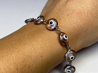 Bracelet worn on wrist showing linked circular "devils eye" motifs and overall look on a wrist.
