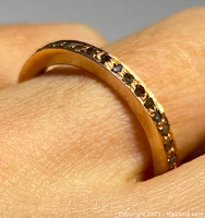 Close-up photo of the antique sterling silver and rose-gold gilt diamond eternity ring on a finger showing the diamonds embedded in the band.