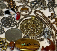 Close-up of various pendants, brooches, chains, and earrings on white board