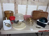 Table display showing picnic basket, scoops, cake container, baskets and part of chandelier frame